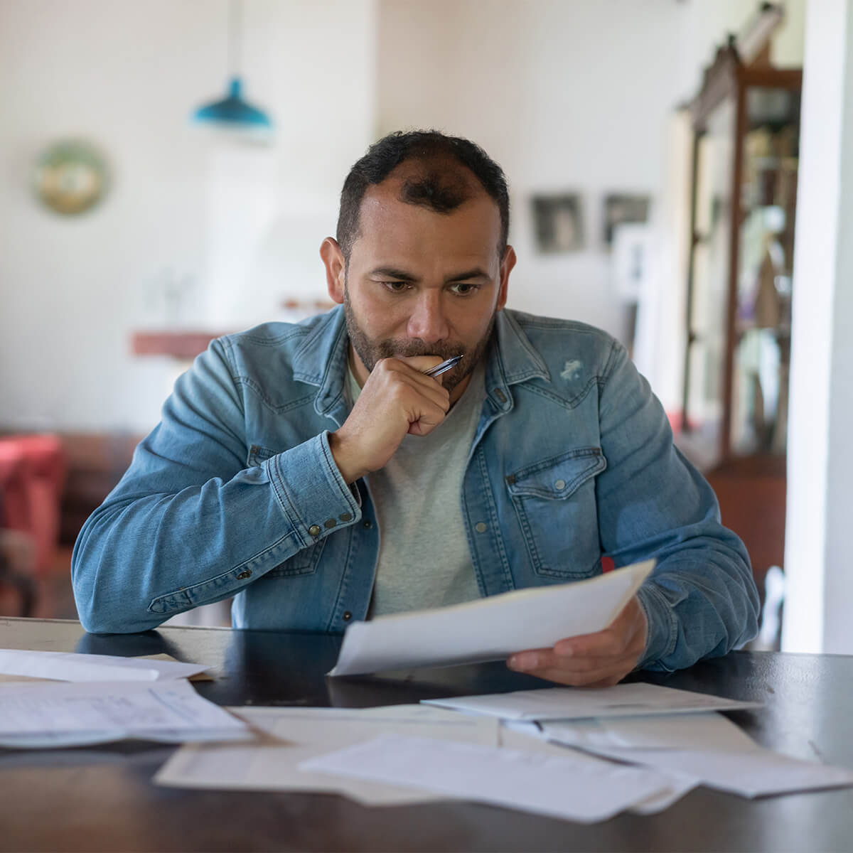 A man holds bills and thinks about filing for bankruptcy