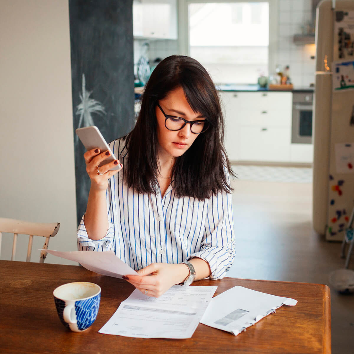 Femme avec ordinateur et smartphone dans la salle à manger