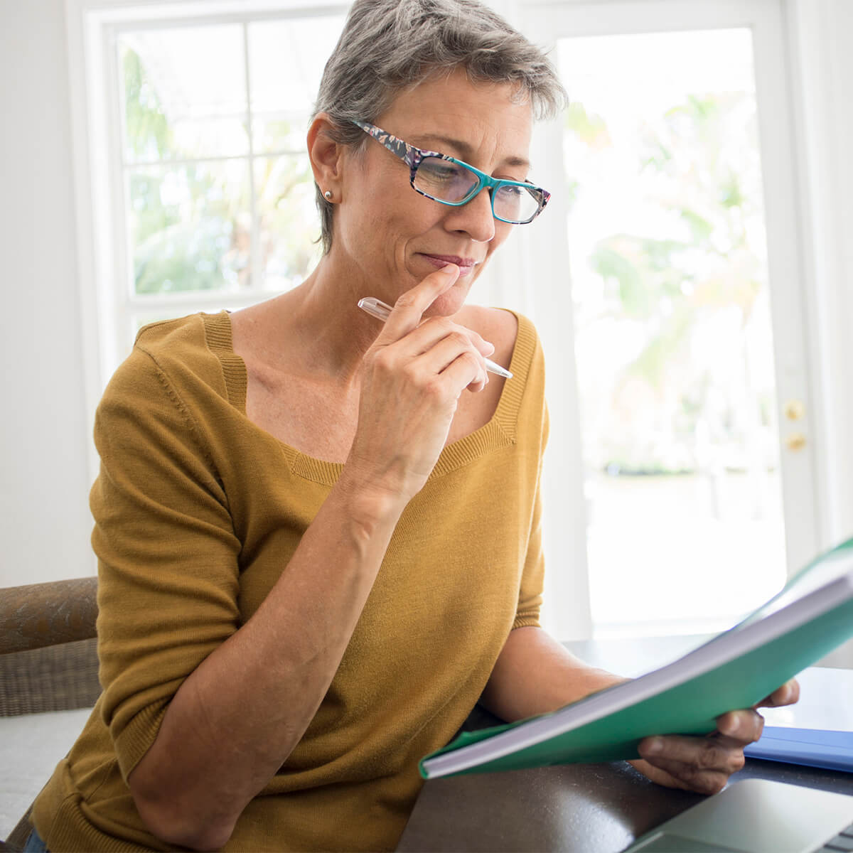 Une femme regarde un document et songe à une solution à l'endettement