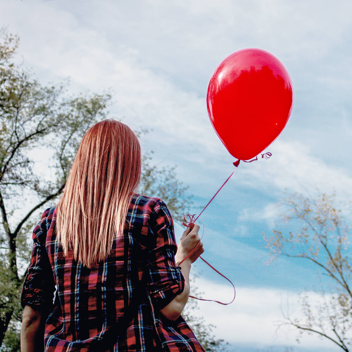 Une femme tenant un ballon rouge