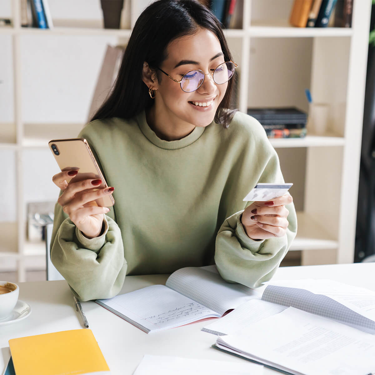 Happy optimistic young girl student holding credit card.
