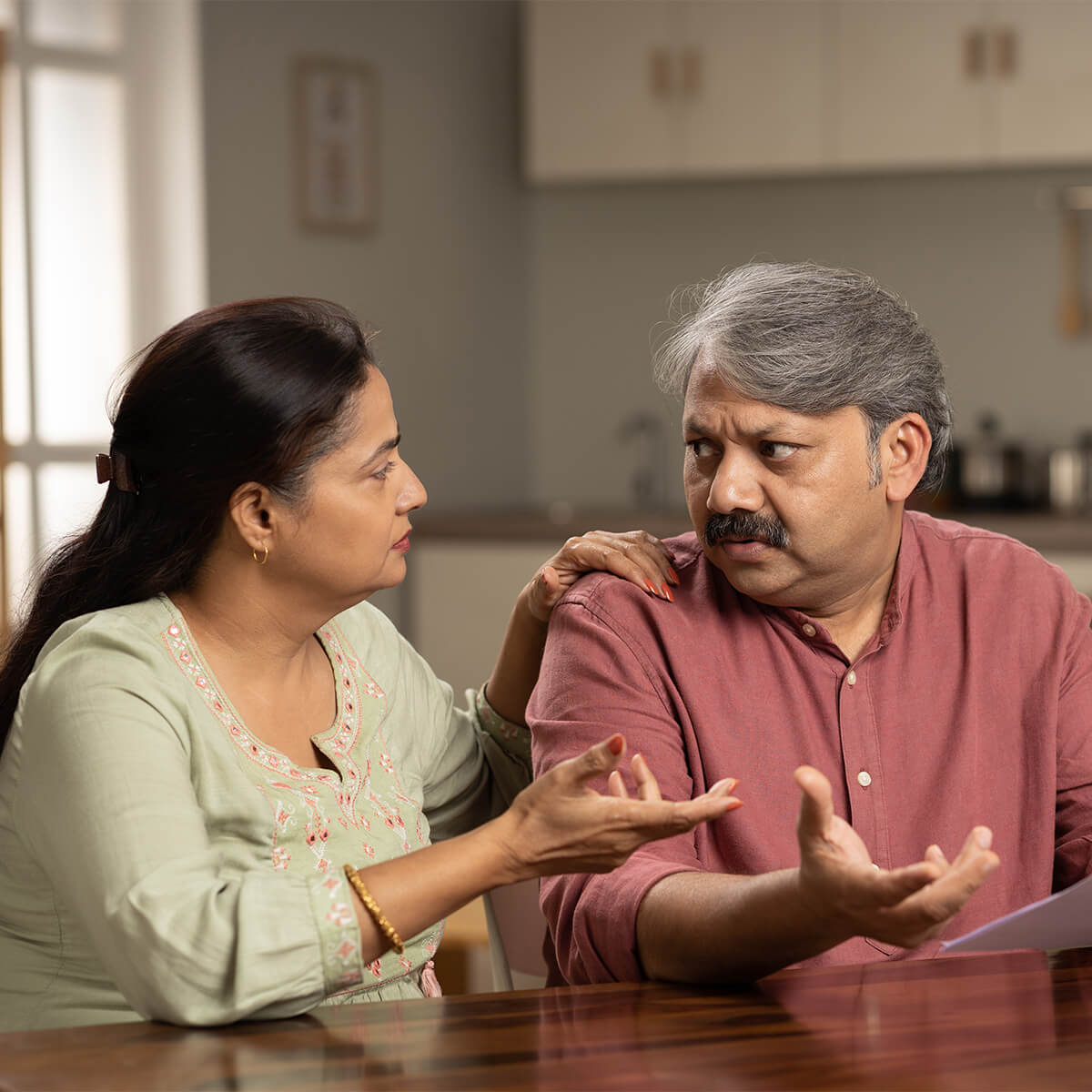 Une femme et un homme sont assis à une table et parlent d'une facture
