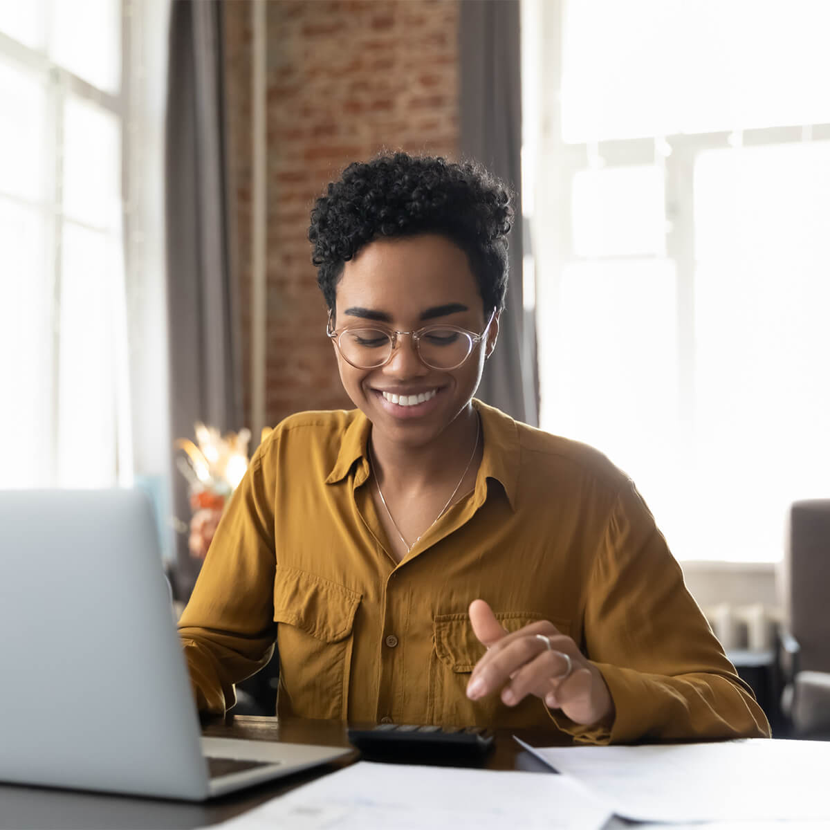 Woman using calculator and computer as a budgeting method