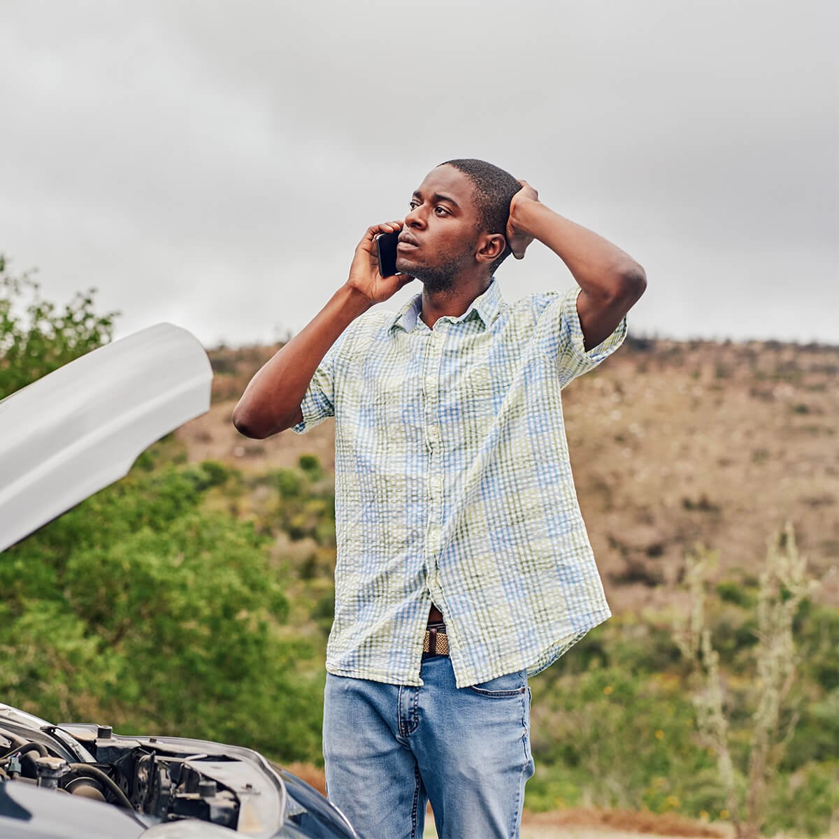 A man who needs car repairs calls for help