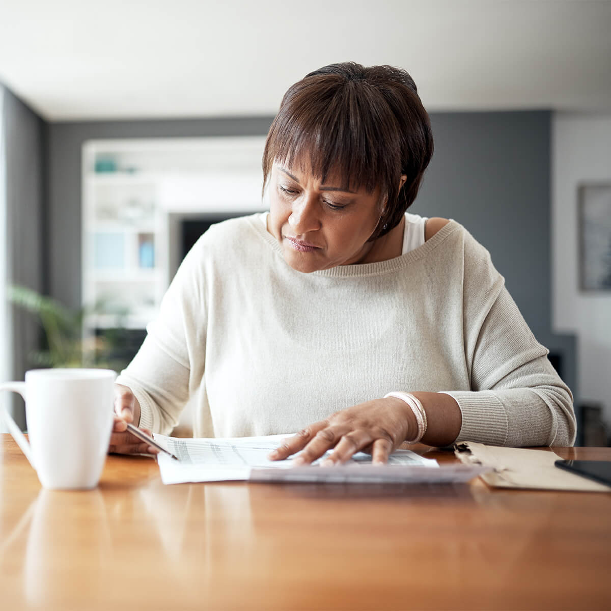 Une femme assise regarde des factures