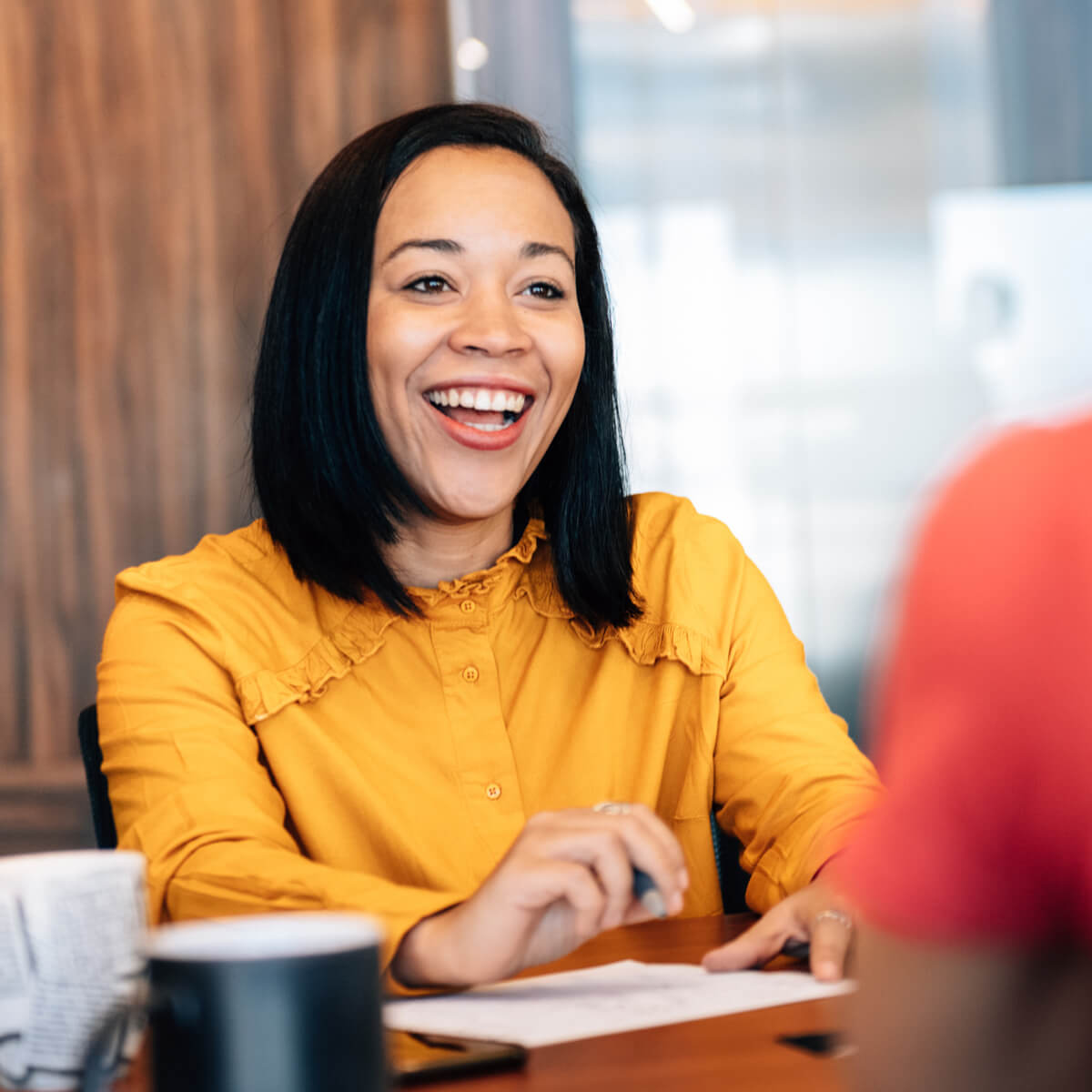 Une femme souriante est assise à une table