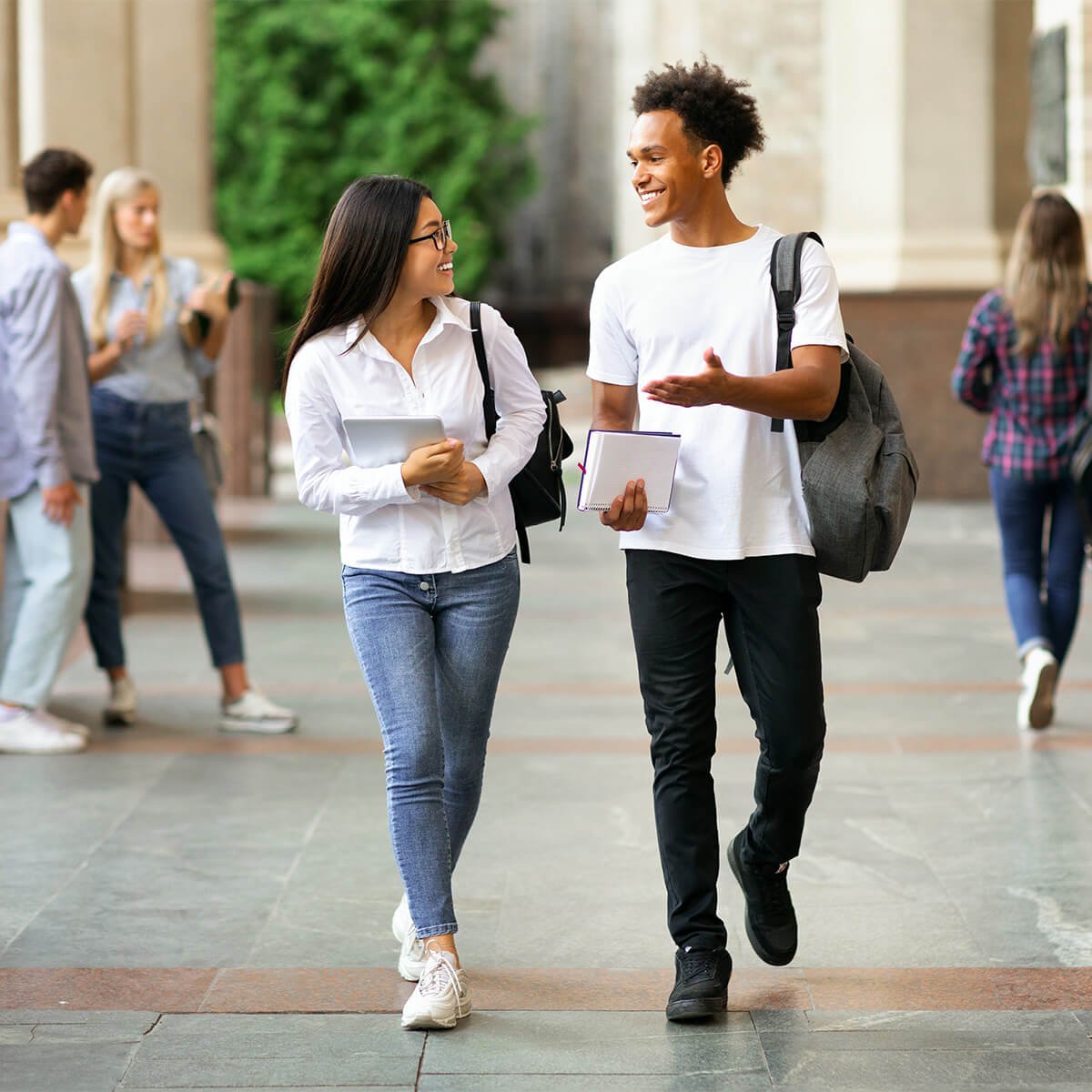 Happy students walking around their university campus