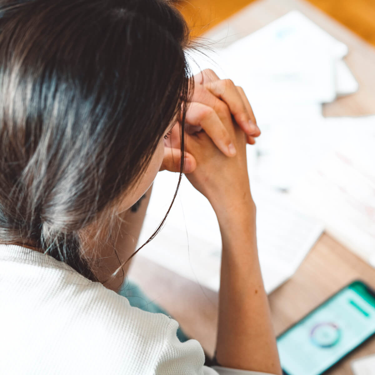 une femme regardant des factures l'air décourarée