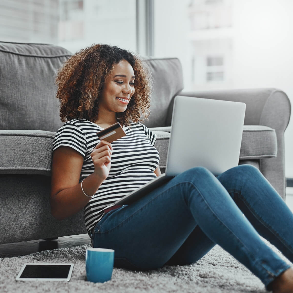 Woman looking at computer while holding credit card
