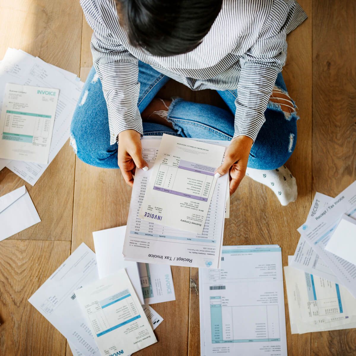 A person needing debt help looks at a pile of bills