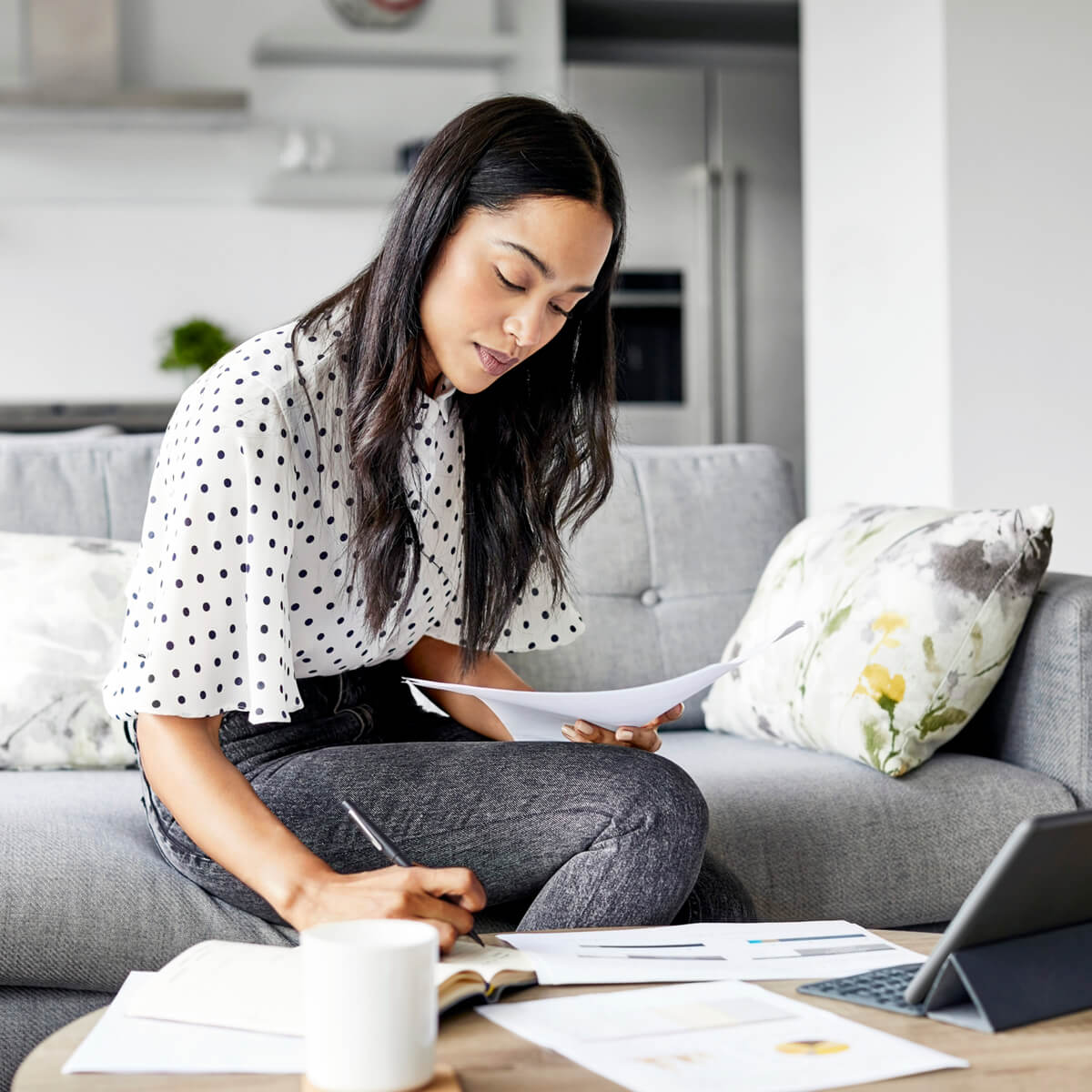 Woman sitting on sofa writing