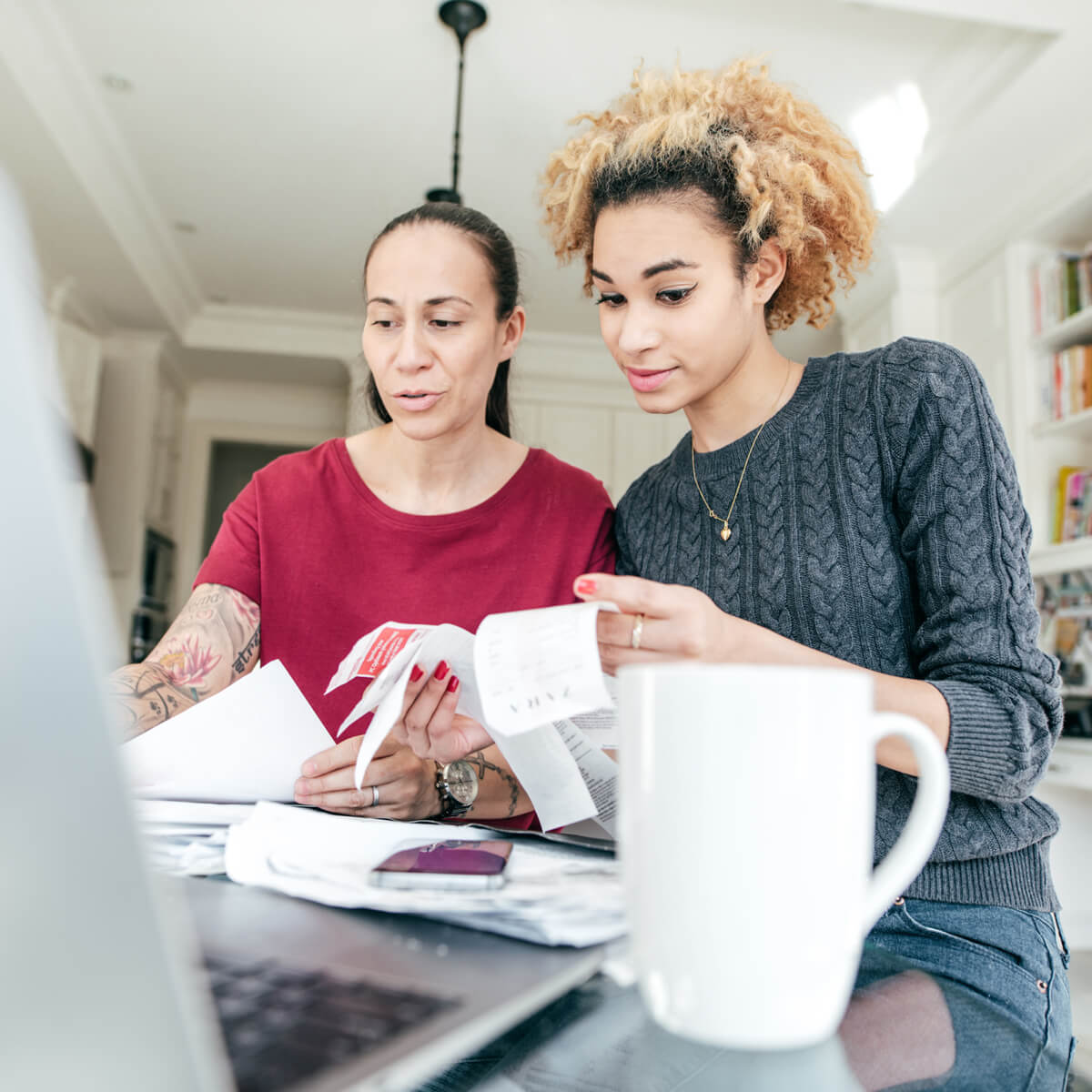 Deux femmes regardent des factures devant un ordinateur