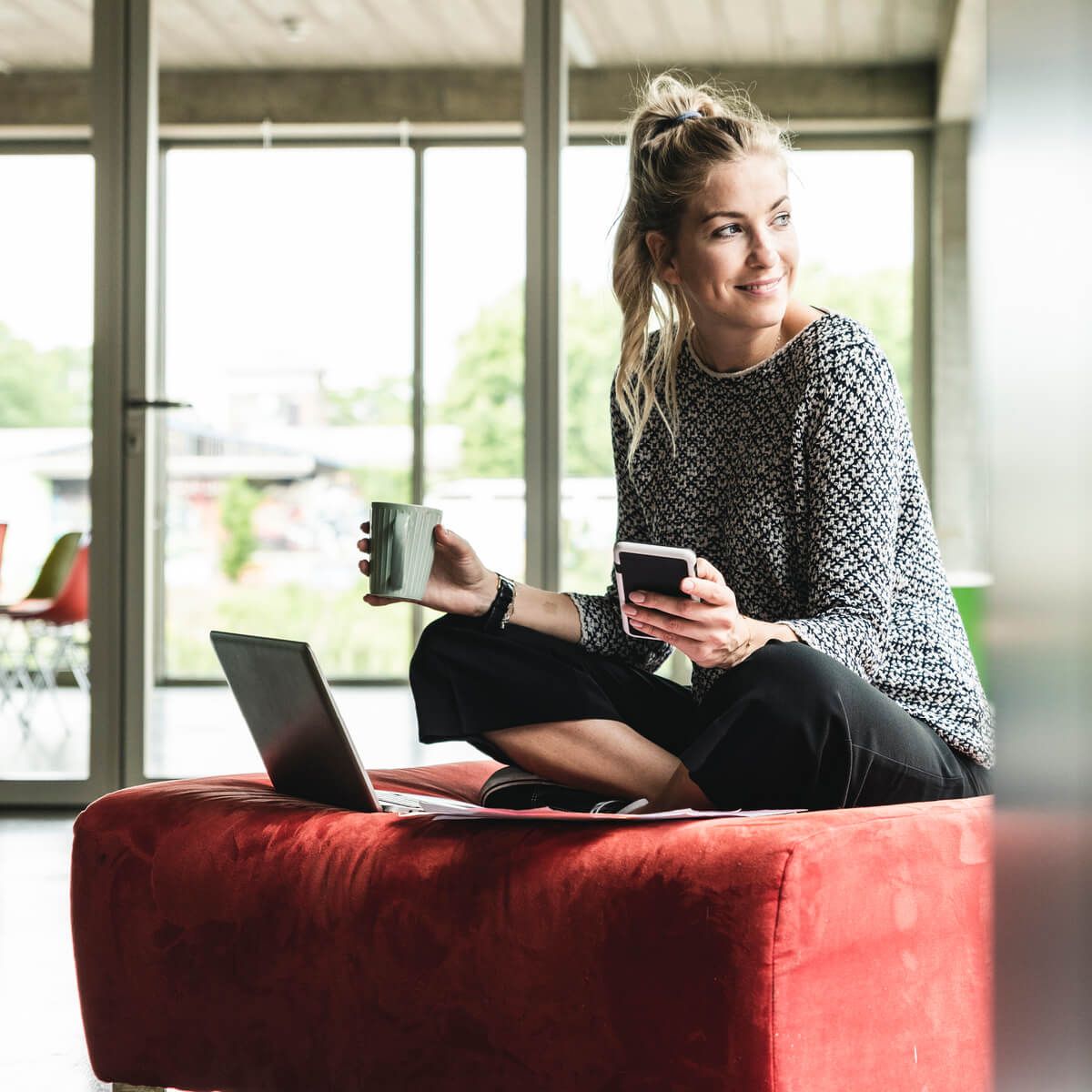 Woman sitting with coffee and phone