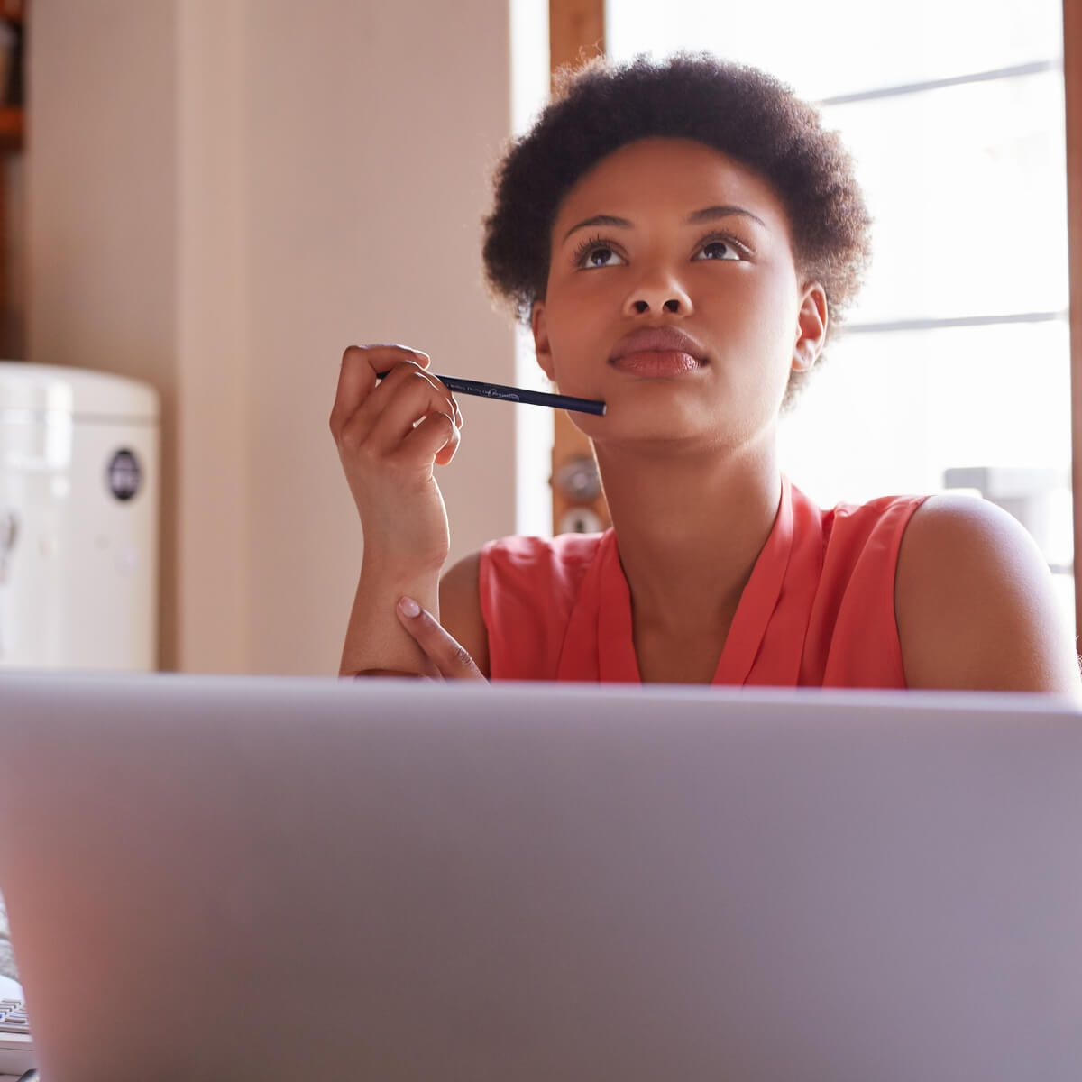 Une femme est assise devant un ordinateur portable tout en travaillant sur un budget